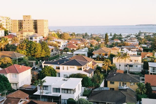 Aerial view of an established Australian coastal suburb with homes of varying ages and rooflines
