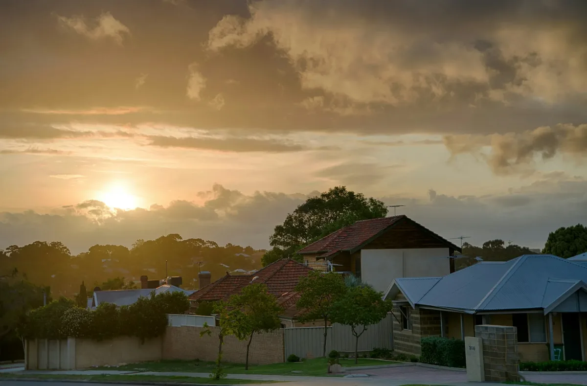 Suburban Perth houses and trees under a cloudy sky at sunset Suburban Perth houses and trees under a cloudy sky at sunset