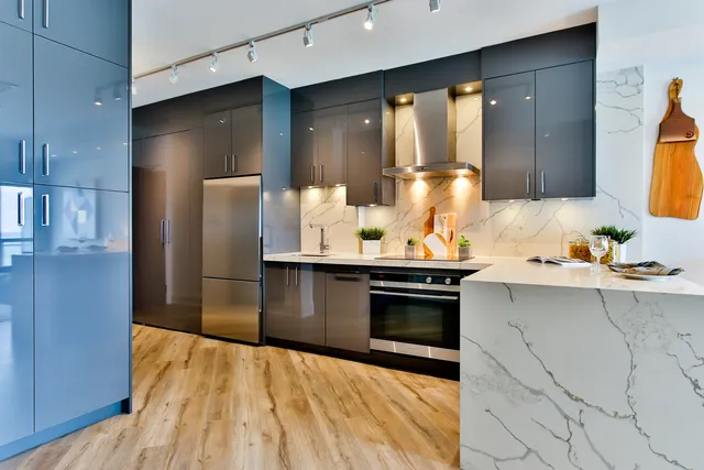 Modern kitchen with grey cabinets, marble benchtops and light timber flooring