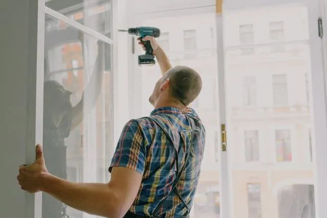 Tradesperson installing a window in a residential investment property an example of capital works