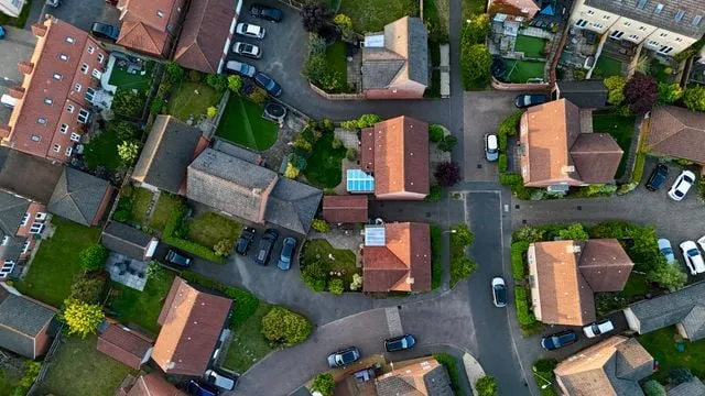 Aerial view of a suburban street with houses, driveways and gardens