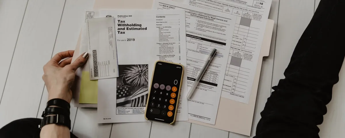 Person reviewing financial statements with calculator