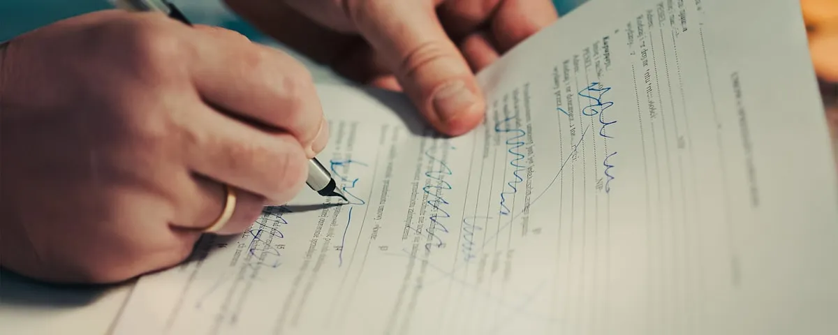 Hand signing a property transaction document