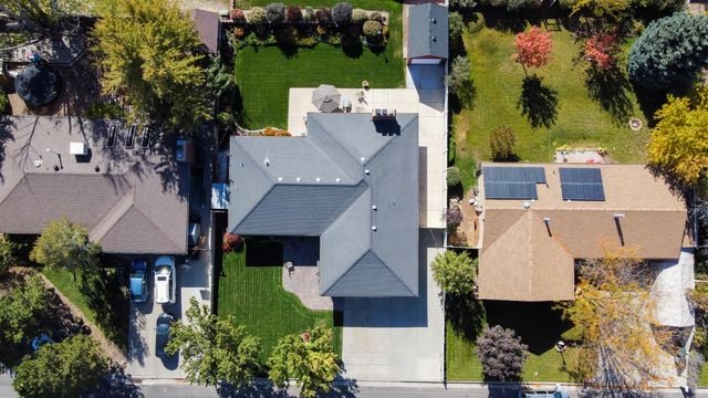 Aerial view of a suburban house with a tiled roof, surrounded by neighbouring homes and backyards