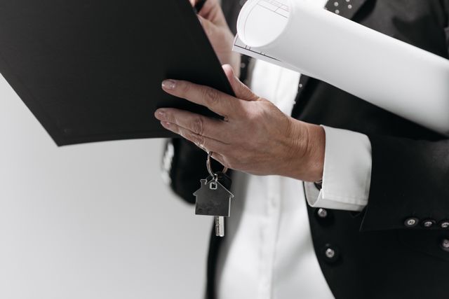 Independent Property Valuations: CGT, SMSF and stamp duty explained » independent property valuation Person in business attire holding house keys and a property blueprint